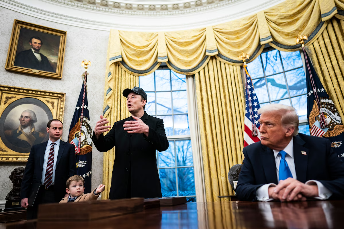 Elon Musk, with his son X Æ A-Xii, speaks with President Donald Trump and reporters in the Oval Office at the White House on Tuesday.