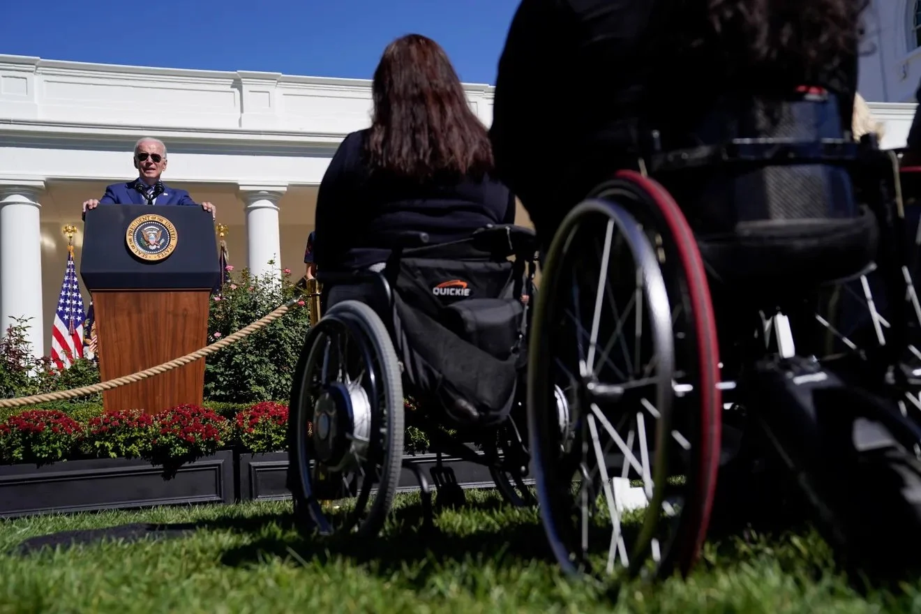 Wheelchair users are seen in the Rose Garden at the White House as President Biden delivers remarks during an ADA celebration.